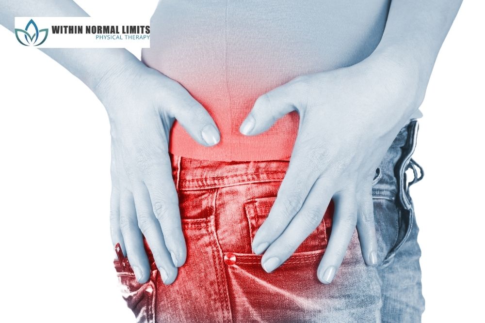Person holding their lower back with both hands, highlighting the area in red to indicate pain or discomfort. "Within Normal Limits Physical Therapy" logo is visible in the upper left corner.