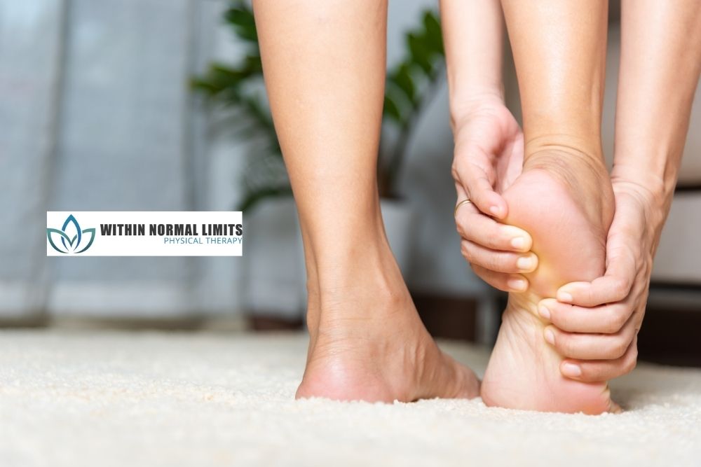 Close-up of a person standing on one foot while holding their heel, with a "Within Normal Limits Physical Therapy" logo in the background.