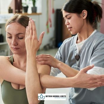 A physical therapist assists a woman with a shoulder stretching exercise in a clinic.